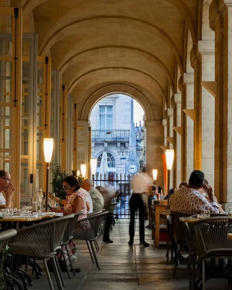 Le Quatrième Mur terrace, Philippe Etchebest’s restaurant, under the stone arcades at sunset